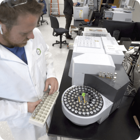 Lab scientist adding test tubes to a centrifuge